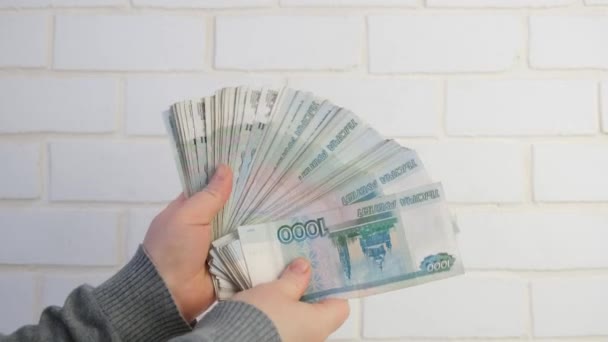 Kobiety liczą pieniądze, 1000 rubli na tle ceglanego muru, dużo pieniędzy. — Wideo stockowe