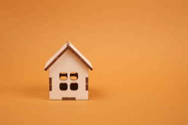 Kahverengi arka plandaki ahşap ev modeli, oyuncak evi, emlak konsepti.