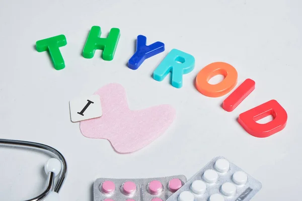 medicine, stethoscope, felt thyroid gland and the inscription from plastic letters thyroid gland on gray background, thyroid awareness month concept, diagnosis and treatment of thyroid diseases