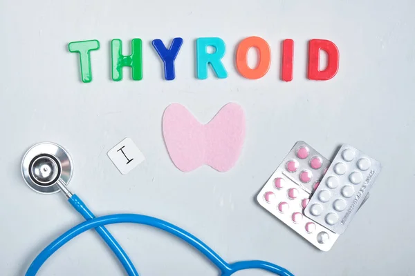 medicine, stethoscope, felt thyroid gland and the inscription from plastic letters thyroid gland on gray background, thyroid awareness month concept, diagnosis and treatment of thyroid diseases