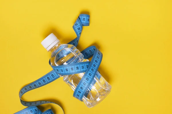 Plastikowa Butelka Wody Taśmą Pomiarową Żółtym Tle Kopia Przestrzeń Widok — Zdjęcie stockowe