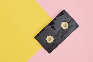 Pembe ve sarı arkaplanda video kaset, antika video kaset kopya alanı üst görünümü