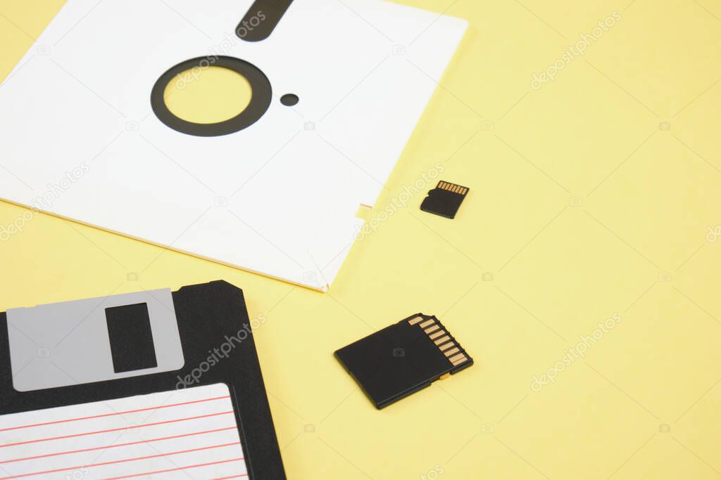 various types of disks for storing information on a yellow background, modern flash cards and retro floppy disks