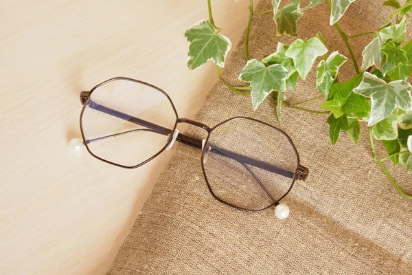 Stylové Oční Brýle Rostlinné Listy Plátně Hnědé Pozadí Kopírovat Prostor — Stock fotografie