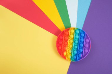 oyuncak anti-stresi gökkuşağı arka planına yerleştir, oyuncak, kabarcıklar patlat ve sakinleş, el ve parmak hareketlerinin gelişimi