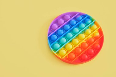 Moda oyuncağı anti-stresi sarı arkaplan kopyalama alanına yerleştir