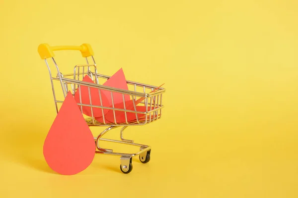 Paper Drops Blood Shopping Trolley Yellow Background World Donor Day — Stock Photo, Image