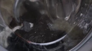 Beyaz çamaşır makinesi çamaşır yıkar. Dönen davul çamaşır makinesinin videosunu kapat.