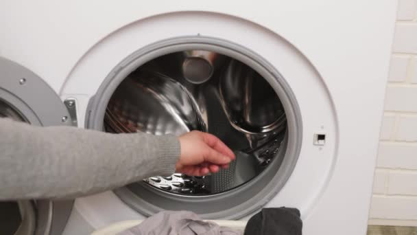 Female hand takes clothes from laundry machine. Loading washing machine. Preparing laundry washing — Stock Video