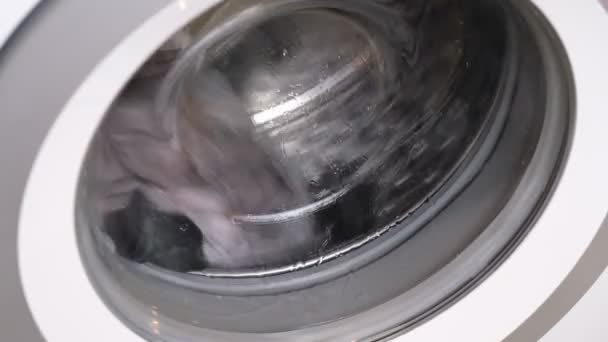 A fehér mosógép ruhákat mos. Záró videó a forgó dob mosógép. — Stock videók