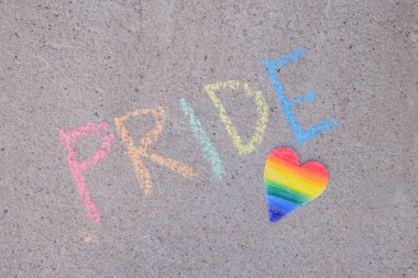 Gökkuşağı renginde boyanmış kağıt kalp lgbt topluluğunun gururu tebeşirle asfalta kazınmış, gurur ayı geçici sanat konsepti