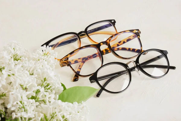 Kilka Różnych Trendów Okularów Gałąź Białego Liliowego Teksturowanym Beżowym Tle — Zdjęcie stockowe