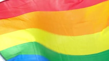 Mavi gökyüzü arka planında gökkuşağı LGBT bayrağı. Igbt gay gurur bayrağı. Mutluluk kavramı. Özgürlük. Eşcinsel çift.