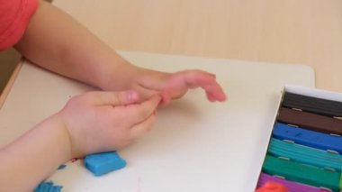 Bir kız plastikten heykel yapar, bir çocuk kartondan plastik çizimler yapar.