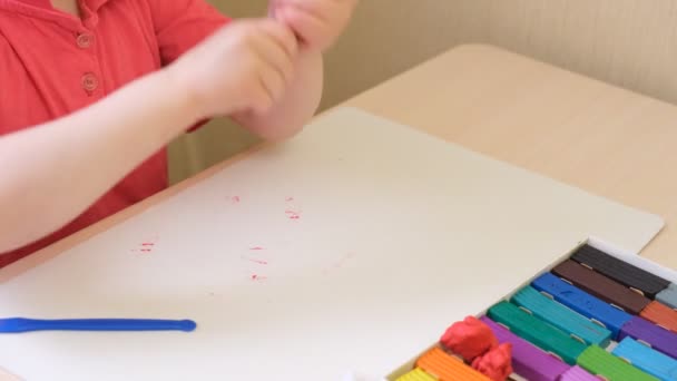 Dívka sochy z plasticinu, dítě dělá kresbu z plasticinu na kartonu — Stock video