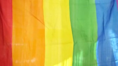 Gökkuşağı LGBT bayrağı pencerede. Igbt gay gurur bayrağı. Mutluluk kavramı özgürlük, aynı cinsiyetten çifti sevmektir.,