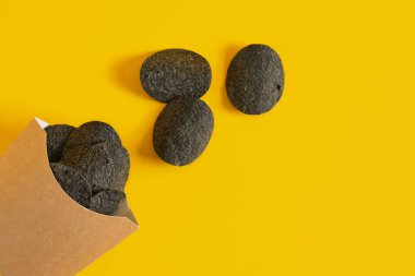 Sarı arka planda patates cipsi paketinde siyah patates cipsi. Kopya alanı, çevre dostu paket.
