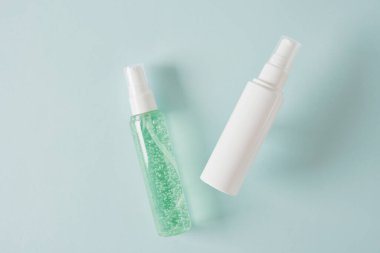 İki farklı boş pompa. Kozmetik için klasik şişe. Açık mavi arka planda kozmetik kabı.