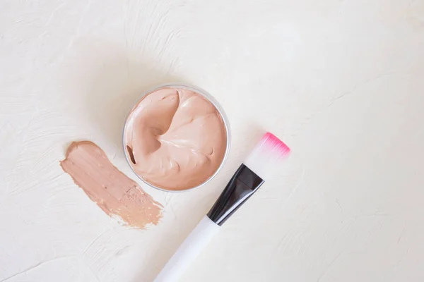 cosmetic brush, open jar with pink clay on light textured background oragnic natural cosmetic concept copy space mock up top view