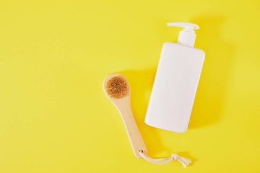 Yeşil arka planda krema şişesi ve masaj fırçası. Yüz masajı ve vücut bakımı konsepti. üst görünüm kopyalama alanı