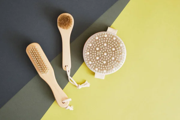 wooden anti cellulite brush with natural bristles for dry body and face massage green geometric background. Lymphatic drainage and exfoliating massage. eco friendly and zero waste lifestyle