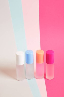 Parlak renkli arka planda farklı renklerde parfüm şişeleri, çizgili arka planda parfüm şişeleri, fotokopi alanı, kozmetik arka plan.