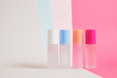 Parlak renkli arka planda farklı renklerde parfüm şişeleri, çizgili arka planda parfüm şişeleri, fotokopi alanı, kozmetik arka plan.