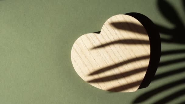 Деревянный подиум в форме сердца на зеленом фоне — стоковое видео