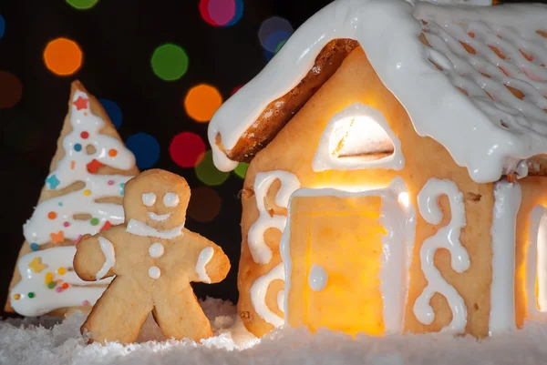 Gingerbread house with gingerbread man and christmas trees — Stock Photo, Image