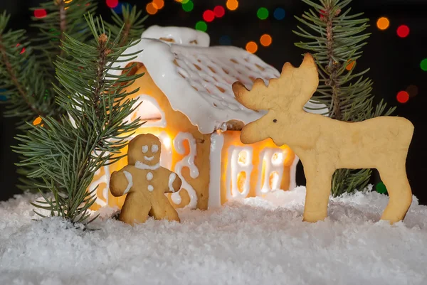 Pepparkakshus med pepparkaksgubbe, älg och julen träd Royaltyfria Stockfoton