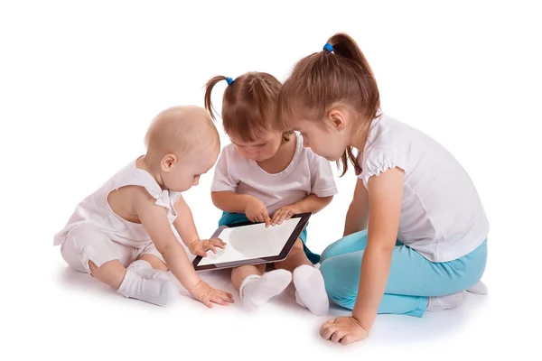 Tablet bilgisayar ile oynayan üç küçük çocuklar