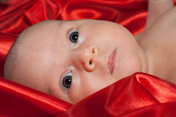 新生児の赤い絹の上に横たわる — ストック写真