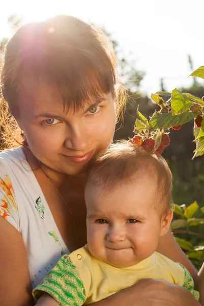 Ung mamma med en liten baby i den soliga trädgården — Stockfoto