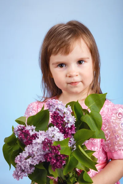 Liten flicka med lila blombukett — Stockfoto