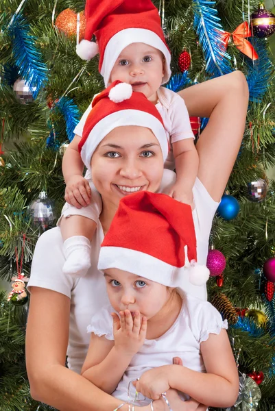 Mother and her little daughters near to a Christmas tree — Stock Photo, Image