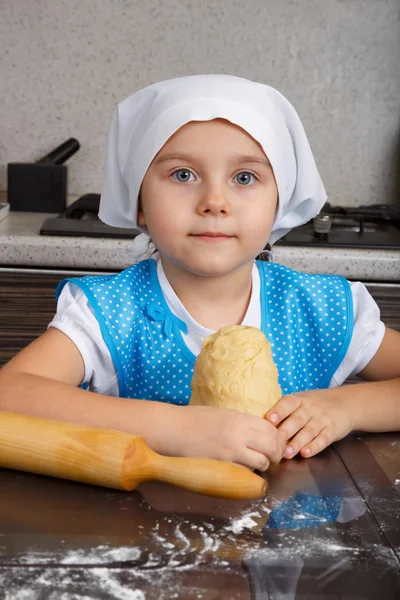 Niña con una pasta y un rodillo — Foto de Stock