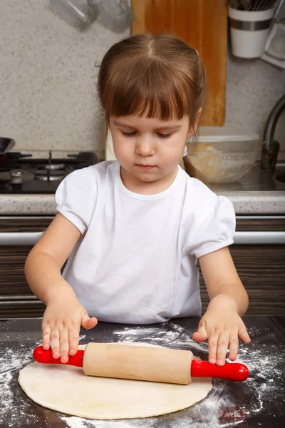 Niña con una pasta y un rodillo — Foto de Stock