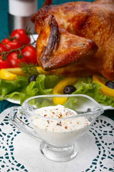 Weiße Knoblauchsauce vor ganzen gebratenen Hühnchen — Stockfoto