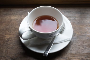 Ahşap masa üzerinde ters gelen çay ve çay bardağı