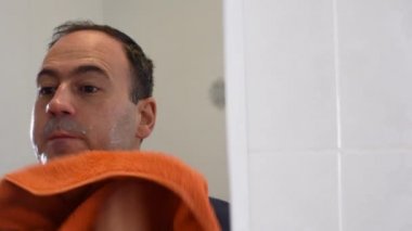 Adam çamaşır yüz ve havlu banyoda ayna üzerinde ile kurutma