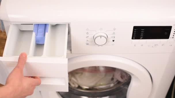 Waschmittelfüllung per Frauenhand in die Waschmaschine