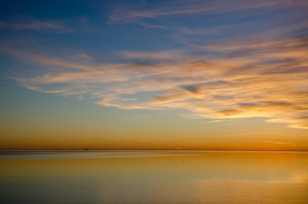 Kesinlikle sakin bir su tarafından renkli günbatımı