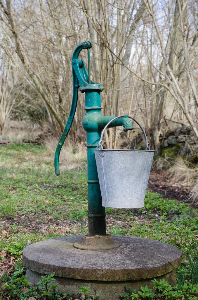 Old hand water pump with a bucket Stock Photo by ©olandsfokus