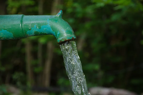 Stänkande vatten från en gård pump — Stockfoto