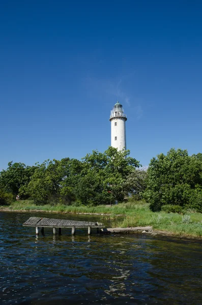 Lighthouse and an old wooden pier — Stock Photo, Image