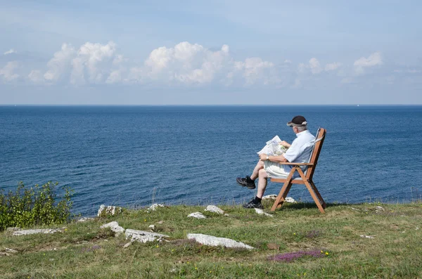 Mann liest Zeitung am Meer mit schöner Aussicht — Stockfoto