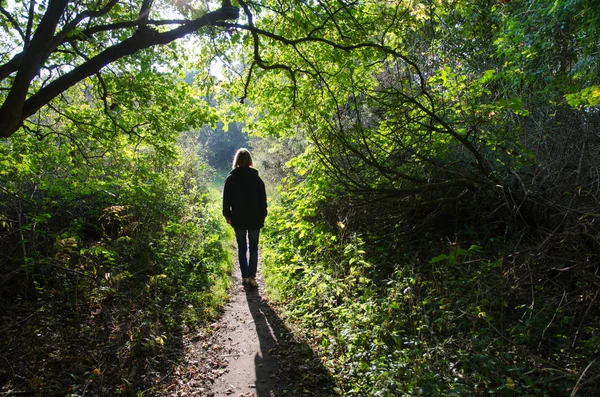 Femme marchant sur un sentier rétro-éclairé — Photo