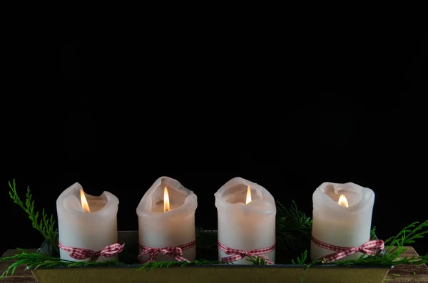 Quatro velas de advento decoradas em fundo preto — Fotografia de Stock