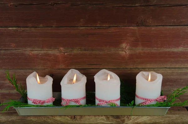 Cuatro velas de adviento en una vieja pared roja envejecida —  Fotos de Stock