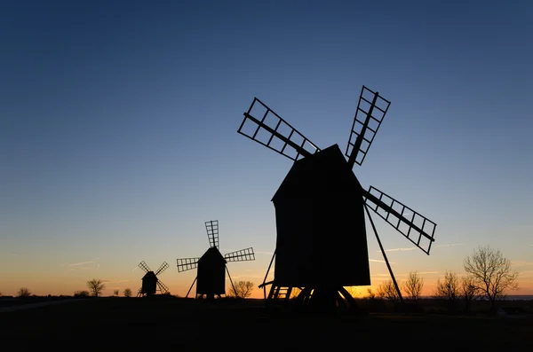 Silhuetas de antigos moinhos de vento ao pôr-do-sol — Fotografia de Stock